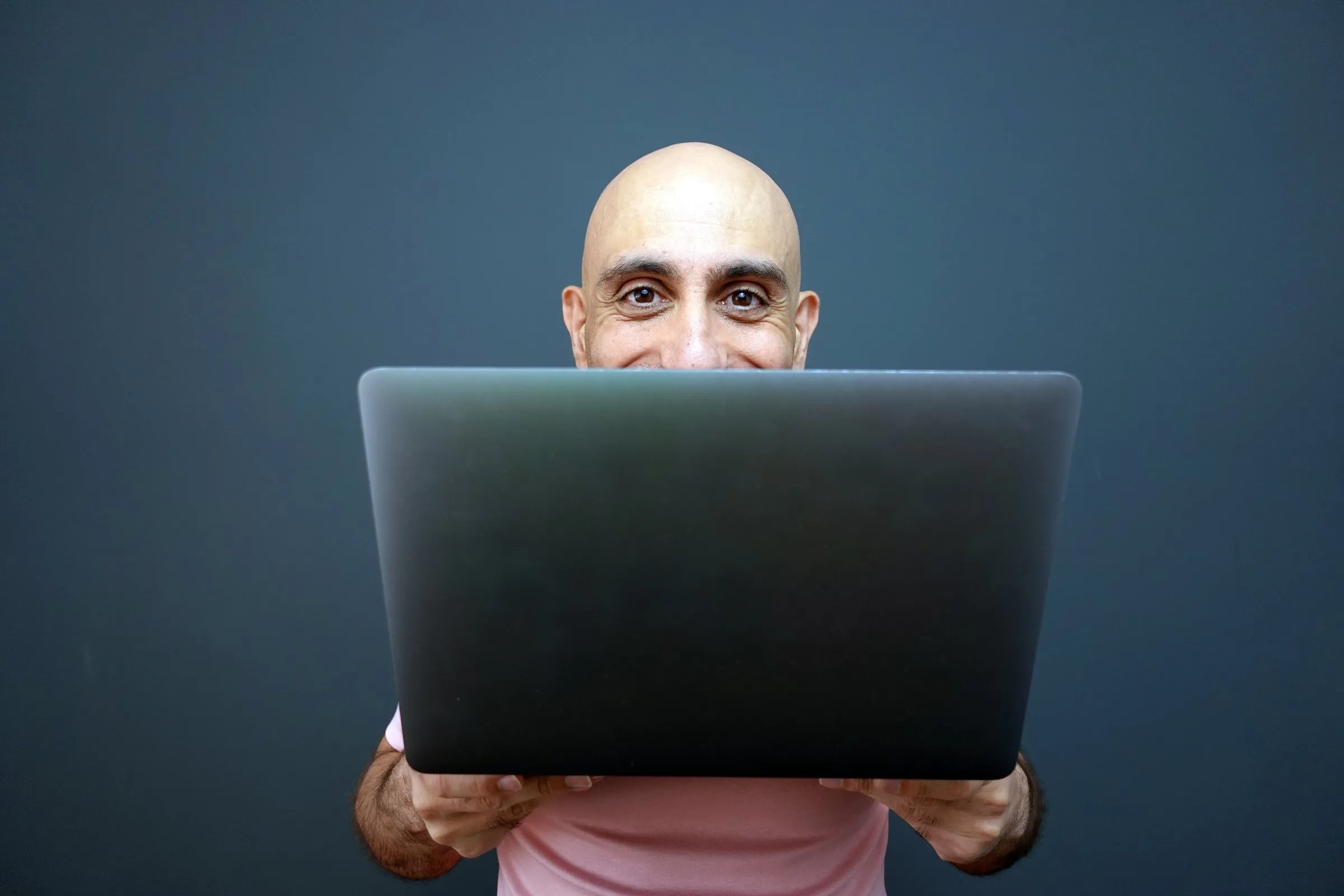 Chris K peering over the top of a laptop
